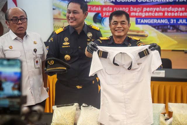 Petugas Bea Cukai Indonesia memperlihatkan seragam pilot Malaysia.