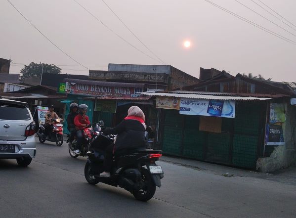 Kabut asap melanda kota Medan, terlihat matahari berwarna kemerahan diabadikan pada Selasa petang di jalan Panglima Denai Medan. (Foto: Fadmin Malau)

