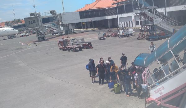 Penumpang antri saat menaiki tangga pesawat di Bandara Soekarno-Hatta Tangerang Banten. (Foto: Fadmin Malau)