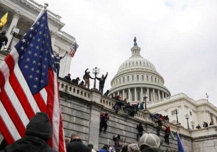 Pendukung Presiden AS Donald Trump memanjat tembok Gedung Capitol saat protes terhadap sertifikasi hasil pemilihan presiden Amerika Serikat 2020 oleh Kongres AS di Washington, Amerika Serikat