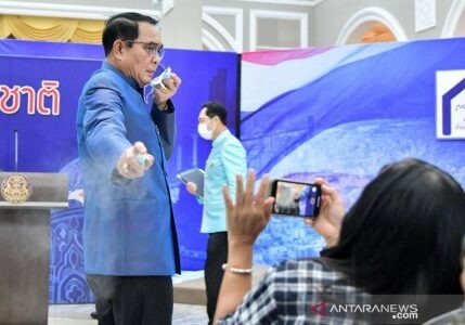 Perdana Menteri Thailand Prayuth Chan-ocha menyemprotkan "hand sanitizer" ke wartawan barisan depan untuk menghindari pertanyaan tentang perombakan Kabinet terbaru di Bangkok, Thailand, (9/3/2021).