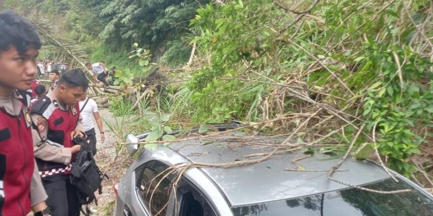Satu unit mobil sedang melintas tertimbun tanah longsor