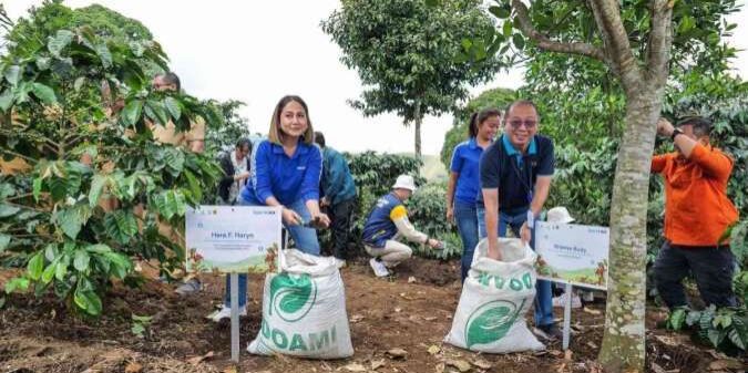EVP Corporate Communication and Social Responsibility BCA Hera F. Haryn melakukan pemupukan pohon kopi di Desa Tugu Utara, Kabupaten Bogor

