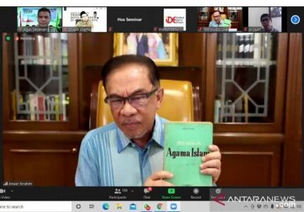 Anwar Ibrahim memegang buku karya Buya Hamka saat seminar di Kuala Lumpur