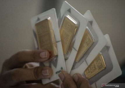 Karyawan menunjukkan imitasi emas batangan Antam di Butik Emas, Jakarta


