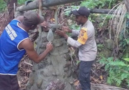 Suasana Bhabinkamtibmas bersama warga Kampung Dosay, Distrik Sentani Barat gotong royong membuat pondasi penahan pipa air | Humas Polres Jayapura