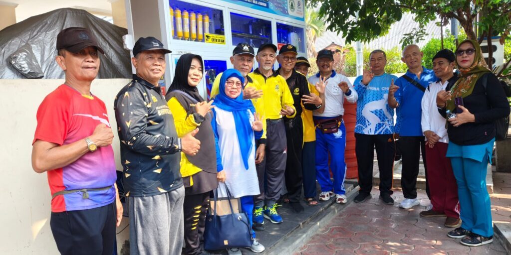 Ketua Eltekers dan Ketua DKM Al Ikhsan berfoto bersama masyarakat di depan Depot Air Mineral Siap Minum.