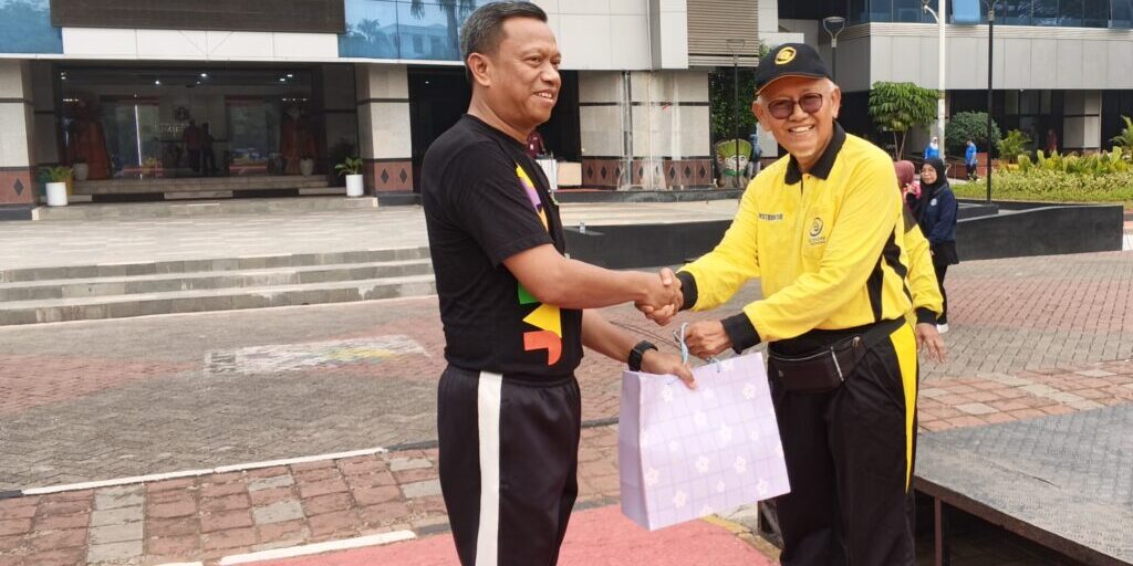 Ketua DPD Ling Tien Kung Jakarta Timur, Ir. H. Mazwar Makmur (kanan), menyerahkan seragam kepada Wali Kota Jakarta Timur, Dr. Munjirin, S.Sos., M.Si. (kiri).