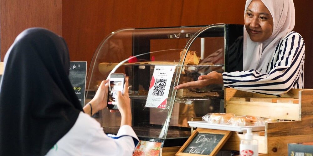 Konsumen melakukan pembayaran melalui pemindaian Quick Response Code Indonesian Standard (QRIS) di salah satu kedai kuliner di Jakarta, Senin (19/12).

