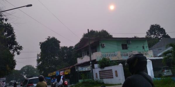 Kabut asap melanda Kota Medan tetapi warga tetap beraktivitas diluar ruangan, terlihat matahari berwarna kemerahan satu ruas jalan di Medan Denai. (Foto: Fadmin Malau)