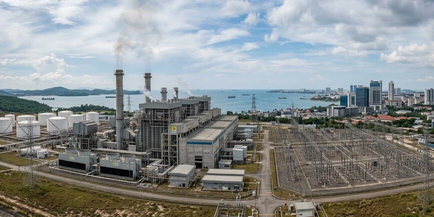 Ilustrasi Pembangkit listrik dan gardu induk PLN Batam dengan latar belakang kawasan industri serta cakrawala kota Batam.