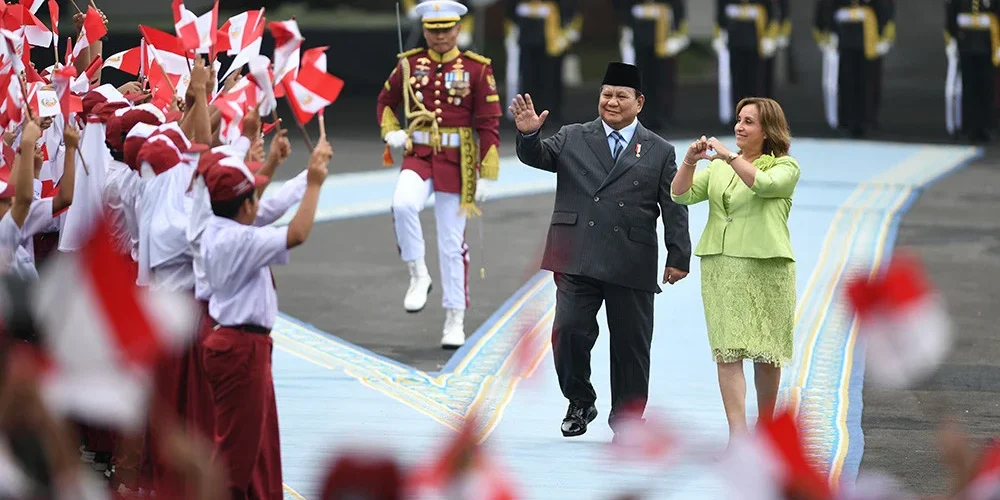 Presiden Prabowo Subianto (tengah) dan Presiden Republik Peru Dina Ercilia Boluarte Zegarra (kanan) melambaikan tangan ke arah para siswa sekolah saat pemeriksaan pasukan di Istana Merdeka, Jakarta, Senin (11/8/2025).

