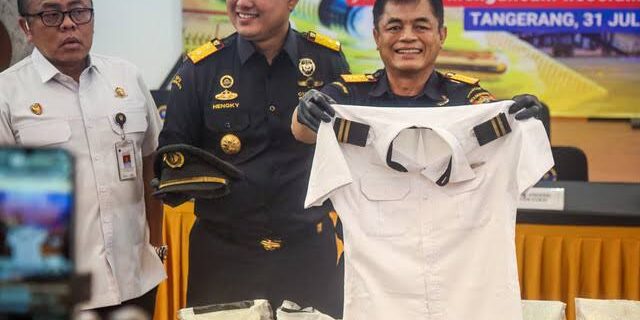 Petugas Bea Cukai Indonesia memperlihatkan seragam pilot Malaysia.