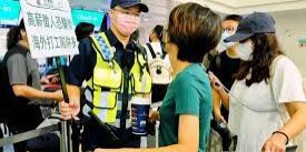 Polisi di Taiwan memegang tanda peringatan bahaya penipuan pekerjaan di luar negeri.