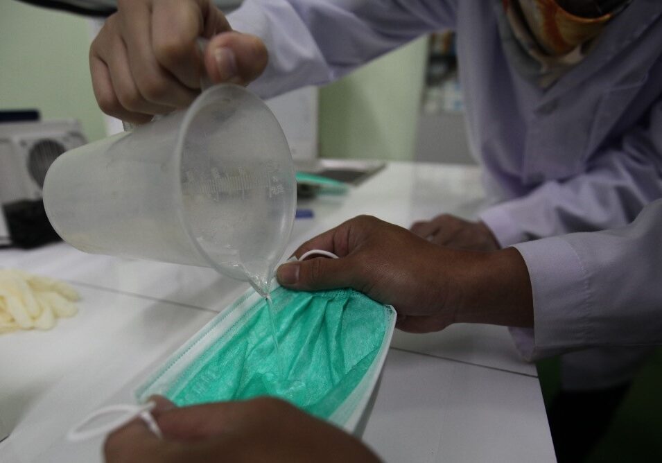 Pekerja mengecek masker bedah yang telah selesai diproduksi

