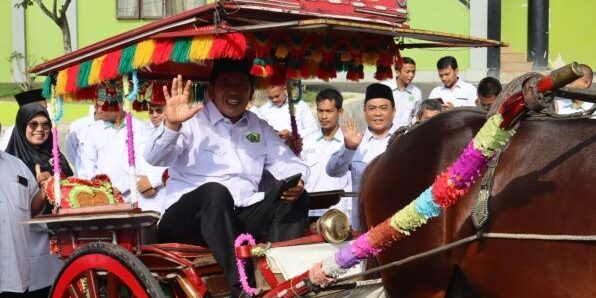 Prof. Sumper Mulia Harahap menaiki sado bagian dari penyambutan adat menuju Gedung Rektorat