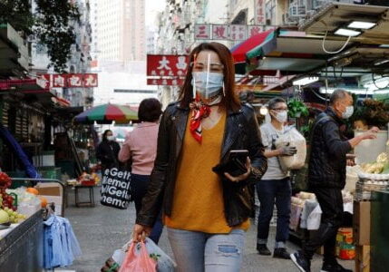 Seorang warga memakai masker dan pelindung wajah saat berjalan di pasar basah di kawasan peemukiman Jorda, Hong Kong, China