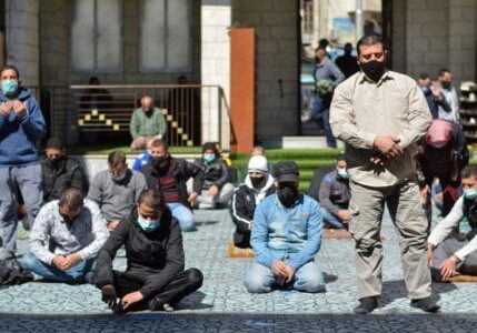 Para pria memakai masker pelindung melakukan ibadah shalat Jumat di masjid al-Husseini, saat Yordania mengumumkan peraturan lebih ketat untuk membatasi penyebaran penyakit virus corona (COVID-19), di Amman, Yordania, Jumat (26/2/2021).