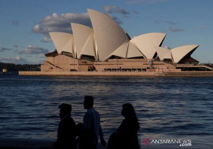 Warga berjalan di depan Sydney Opera House menyusul pelonggaran aturan yang dilaksanakan untuk membatasi penyebaran penyakit virus corona (COVID-19) di Sydney, Australia