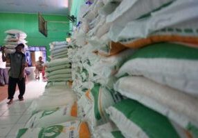 Pekerja memanggul karung berisi beras bantuan di Kelurahan Pringrejo, Kota Pekalongan, Jawa Tengah, Senin (26/2/2024).