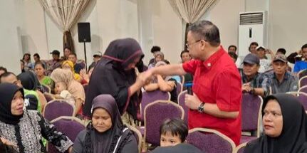 Sofyan Tan charter president Lions Club Medan Kasuari bersama para penerima paket sembako

