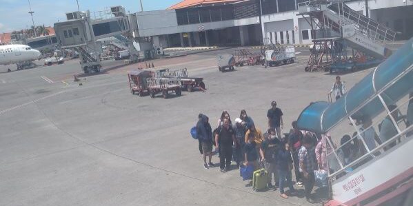 Penumpang antri saat menaiki tangga pesawat di Bandara Soekarno-Hatta Tangerang Banten. (Foto: Fadmin Malau)