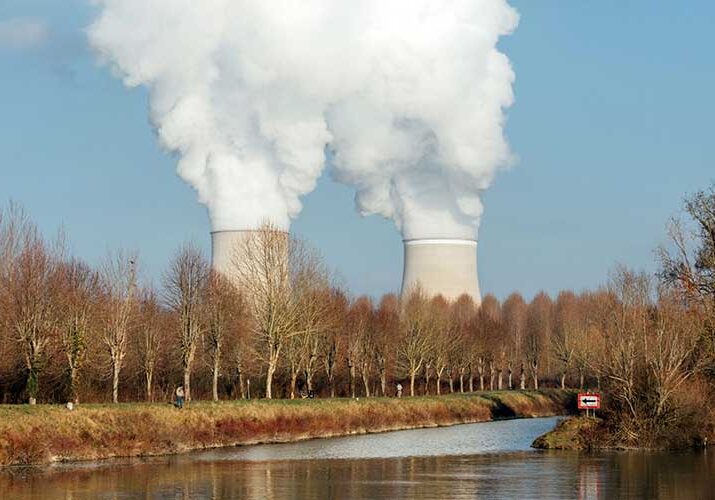 Ilustrasi menara pendingin melepaskan uap air di pembangkit listrik tenaga nuklir.

